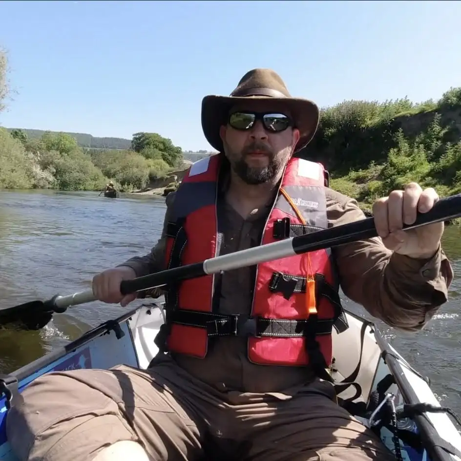 Andrew Davidson (Kent Survival) canoeing on the River Severn, wearing a life jacket and hat, enjoying an outdoor bushcraft adventure.